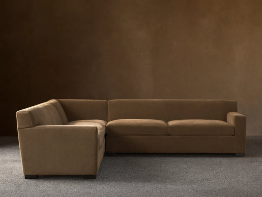 Bronte Three-Piece Corner Sectional in muted olive green fabric, forming an L-shape, on a wood floor against a beige wall.