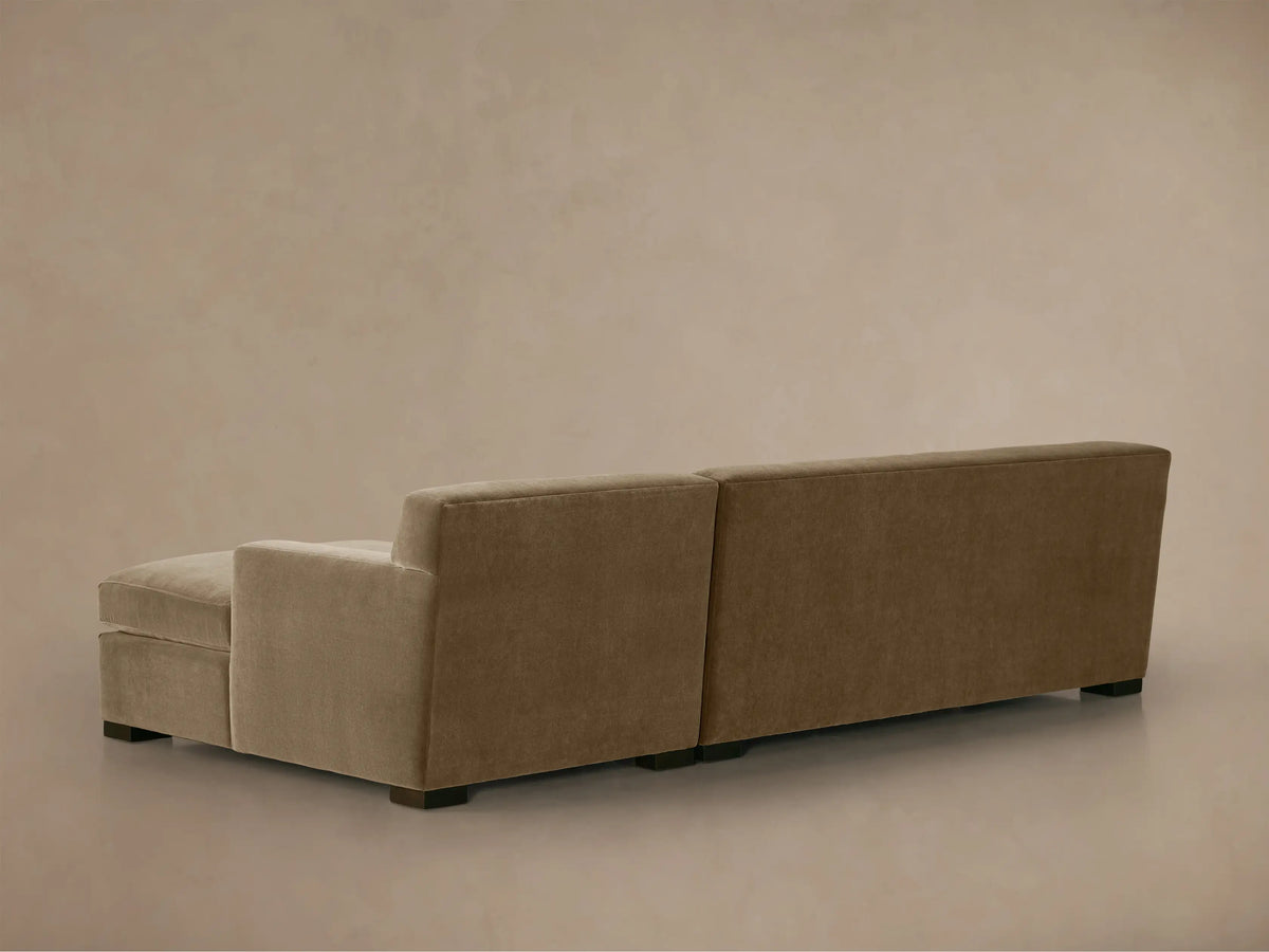 Close-up of a warm brown Bronte two-piece chaise sectional sofa. Soft textured fabric, plush cushions, and a square armrest.