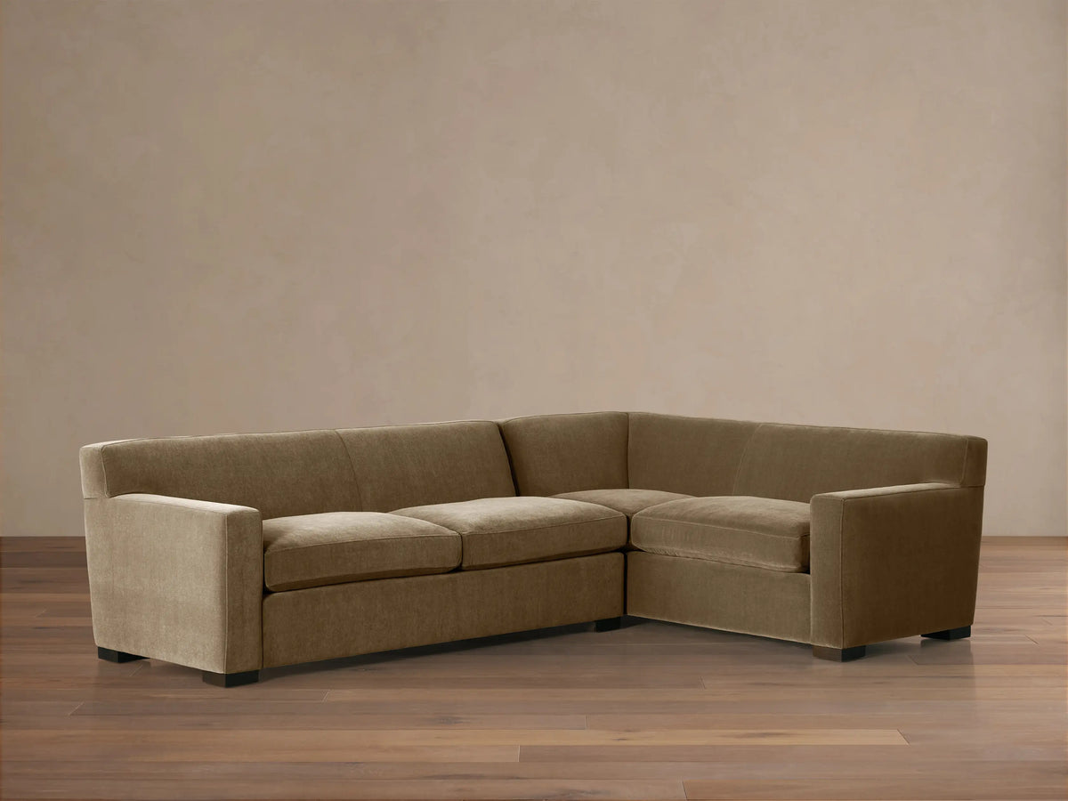 Bronte Two-Piece Sectional, L-shaped, upholstered in muted olive-brown fabric, with dark feet, on a wood floor.