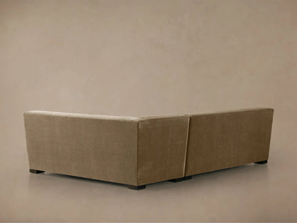 Close-up of Bronte Two-Piece Sectional's corner, showing plush sandy brown fabric cushions and a square armrest.