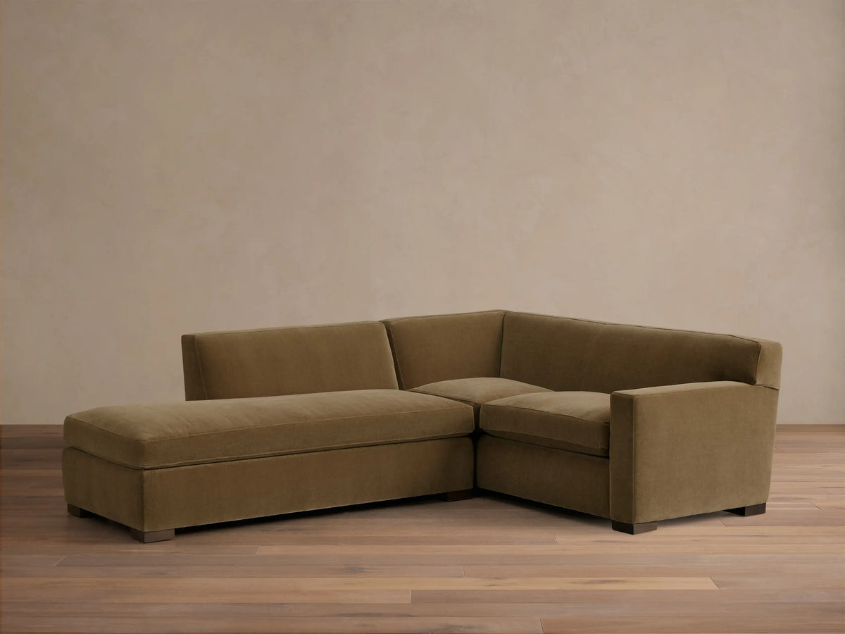 Front view of the olive green Bronte Two-Piece Bumper Chaise Sectional with square arms and dark block legs.