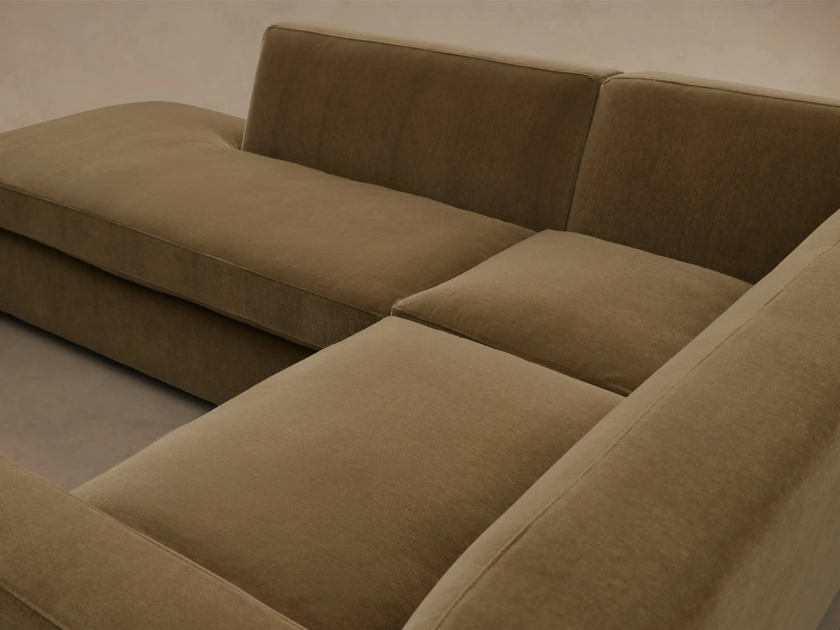 Front view of the olive green Bronte Two-Piece Bumper Chaise Sectional, featuring an L-shape with a long chaise lounge.