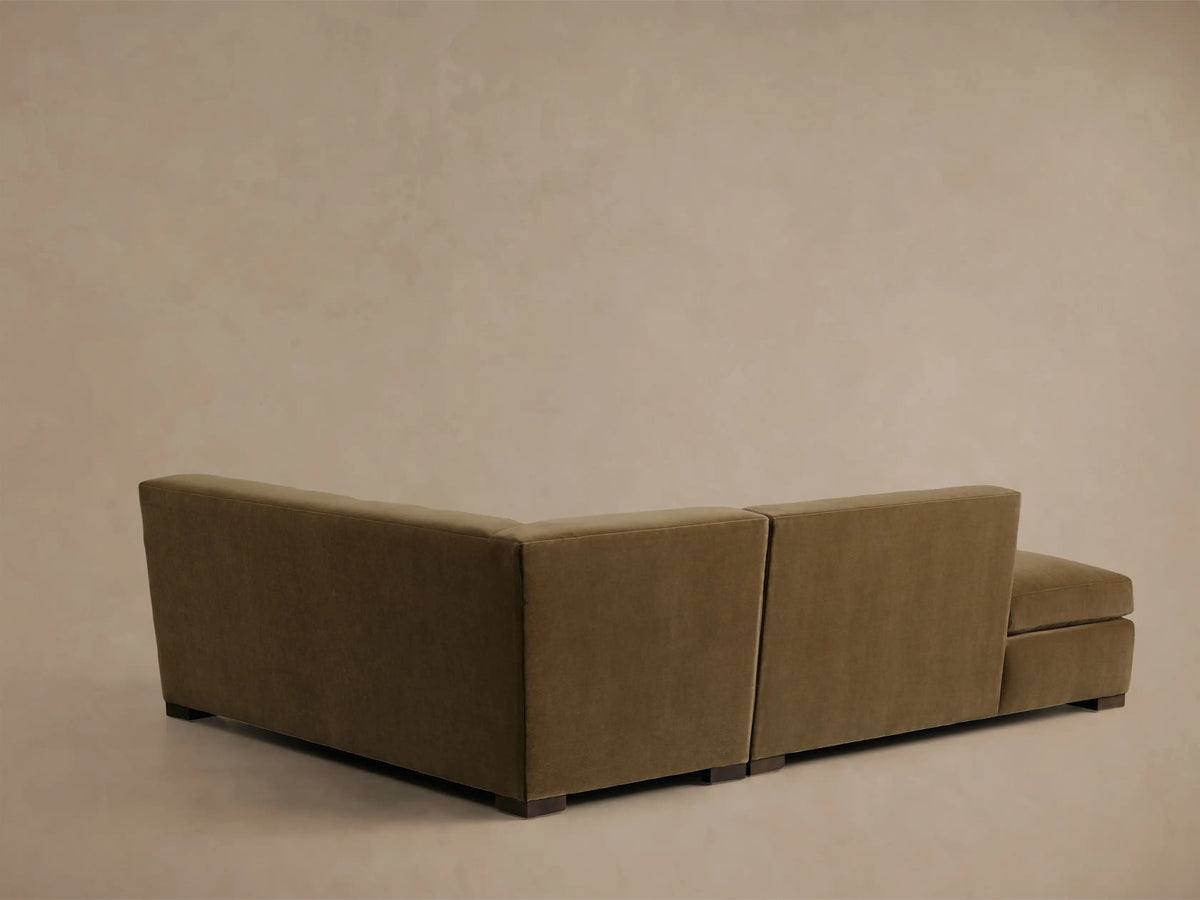 Elevated, partial view of the olive Bronte Two-Piece Bumper Chaise Sectional, highlighting the soft, deep cushions and chaise lounge.