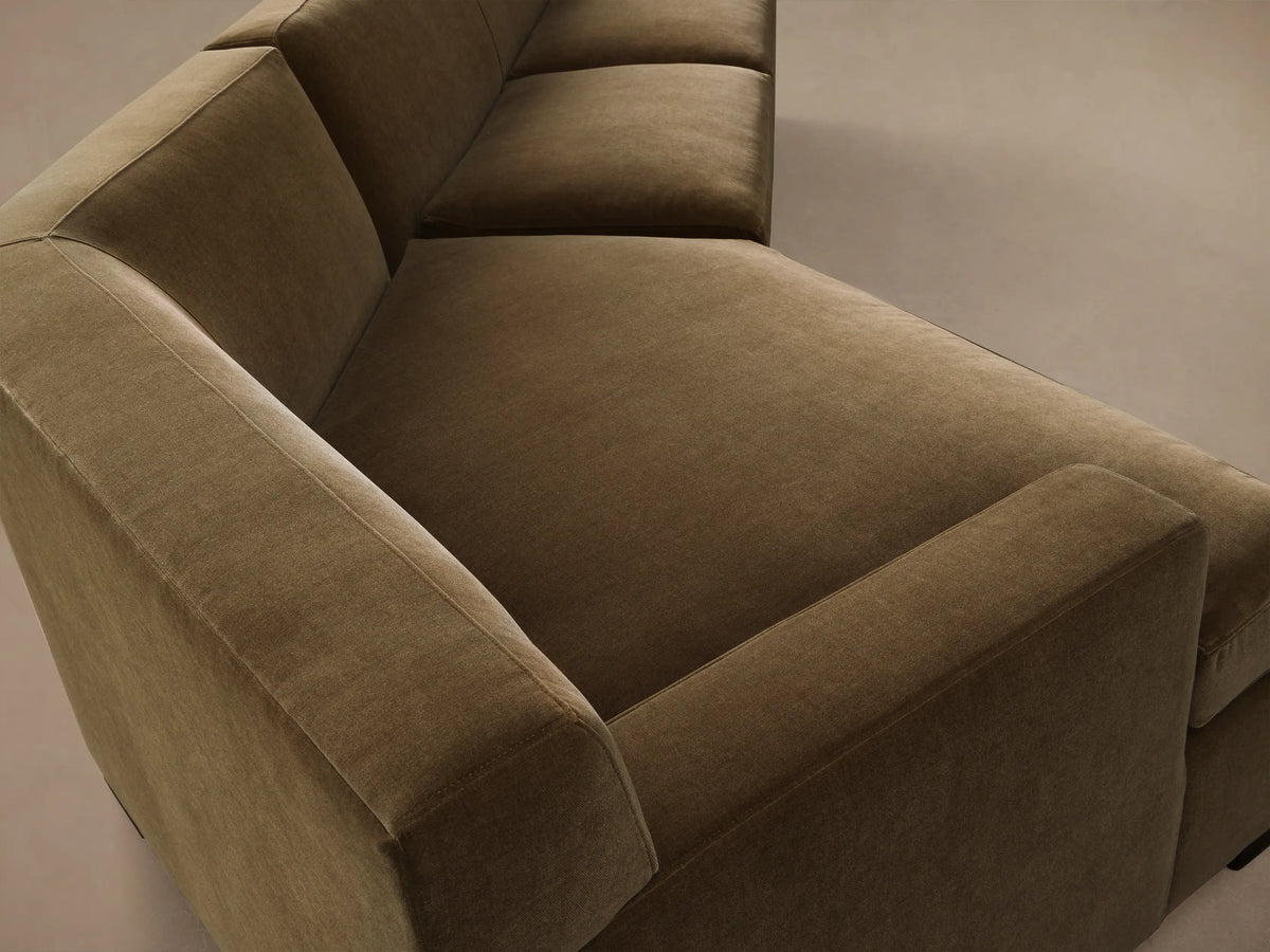 Front view of the olive green Bronte Two-Piece Cuddle Chaise Sectional, an L-shaped sofa with soft velvety upholstery.