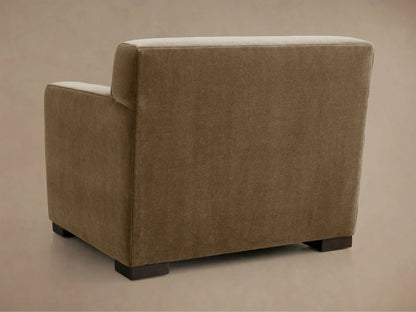 Close-up of Bronte Chair, showing its textured neutral beige upholstery on the seat, armrests, and back cushion, angled view.