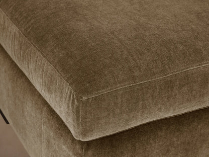 Bronte Ottoman: plush, rectangular, muted olive green fabric. Soft top cushion, dark block feet on a wood floor.