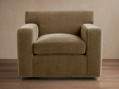 Bronte Swivel Chair, upholstered in textured, earthy brown-green fabric, with clean lines, wide squared arms, on a wood floor.