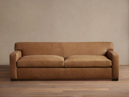 Bronte Leather Sofa in brown leather with a sleek design, featuring straight arms and deep seat cushions on a hardwood floor.