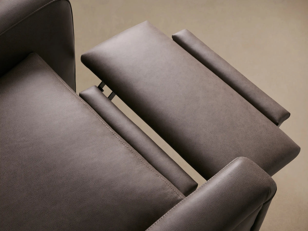 Colfax Leather Motion Recliner, front view. Dark gray leather chair with plush headrest, cushioned arms, and wooden feet.