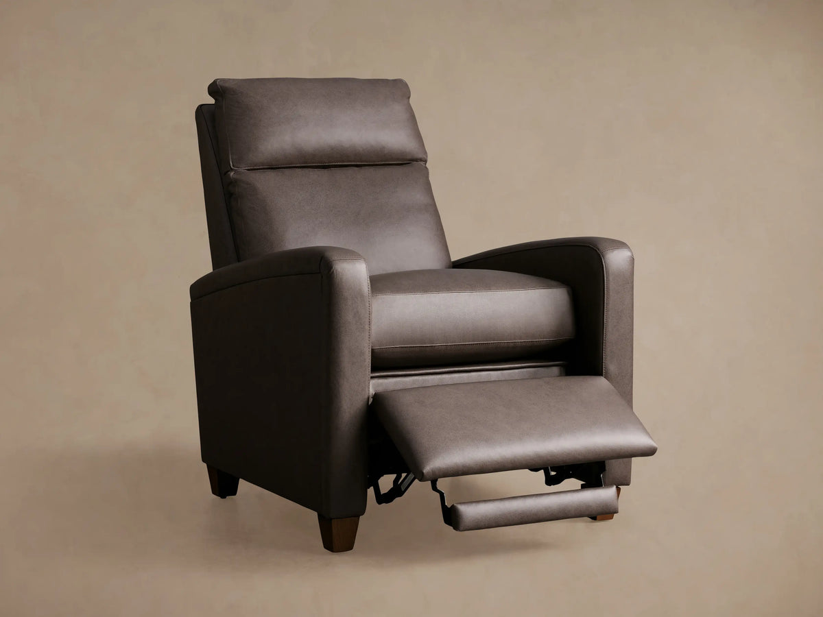 Close-up of Colfax Leather Motion Recliner. Rich dark brown pebbled leather with light stitching and a brushed metal two-button control.