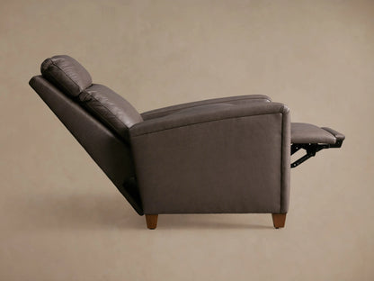 Dark brown Colfax Leather Motion Recliner, slightly angled, with the footrest partially extended, against a light brown wall.