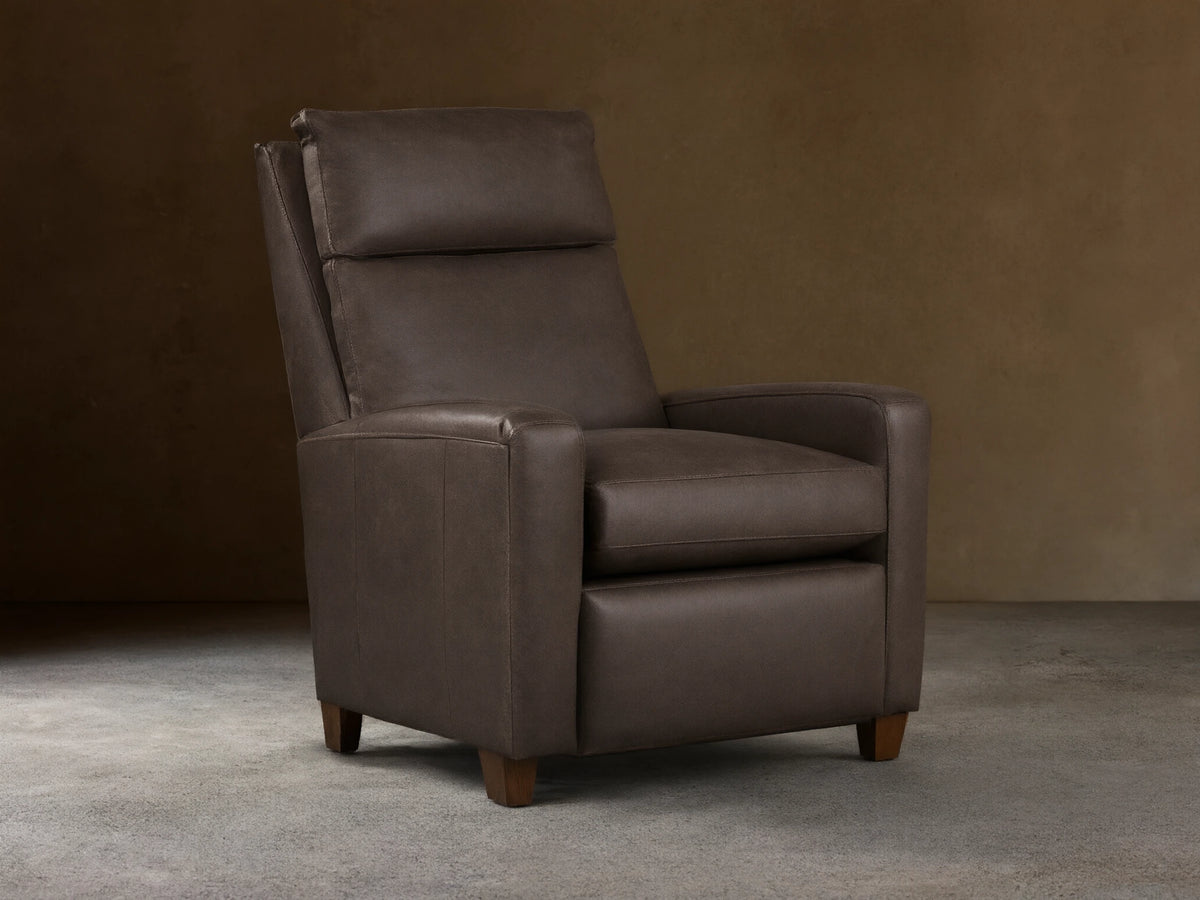 Colfax Leather Motion Recliner, dark taupe leather, upright, with comfortable padded headrest & wood feet, on wood floor.