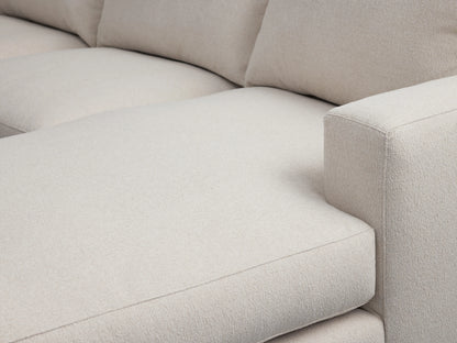 Close-up of Zarevium Dune Chaise Sectional, showing soft, textured light beige fabric seat, chaise extension, and rectangular right armrest.