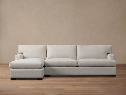 Zarevium Dune Two-Piece Chaise Sectional in light cream fabric, chaise on left, on a wood floor against a beige wall.