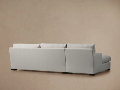 Zarevium Dune Two-Piece Chaise Sectional with light fabric, seen from the back-right. Dark feet visible on a neutral background.