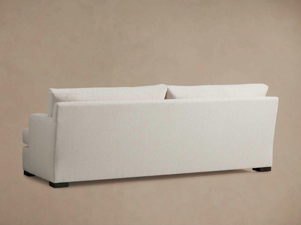 A close-up of the Dune Sofa's corner, showing the textured light beige Crypton fabric on the backrest and armrest against a neutral background.