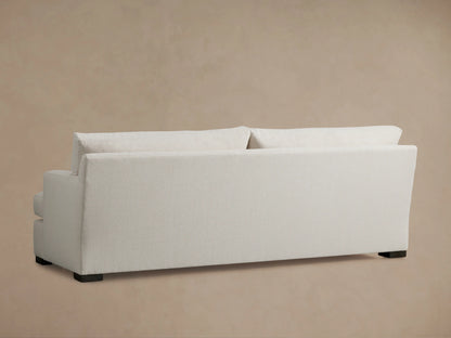 A close-up of the Dune Sofa's corner, showing the textured light beige Crypton fabric on the backrest and armrest against a neutral background.