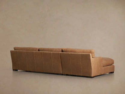 Dune Leather Two Piece Chaise Sectional in caramel brown leather, featuring left chaise, three seat cushions, and subtle stitching details.