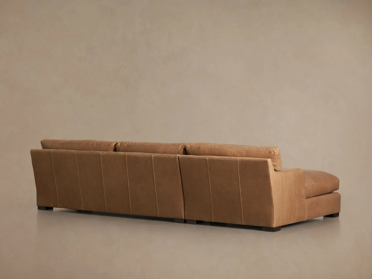 Dune Leather Two Piece Chaise Sectional in light brown leather, features a left-facing chaise and right-facing sofa on wooden floor.