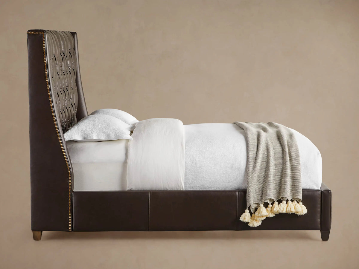 Close-up of Devereaux Leather Tufted Bed headboard. Dark brown leather with deep diamond tufting and antique brass nailhead trim.