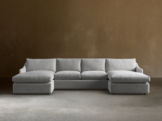 Front view of a plush, light gray Branson Three-Piece Double Chaise Sectional with deep cushions on wooden floor.