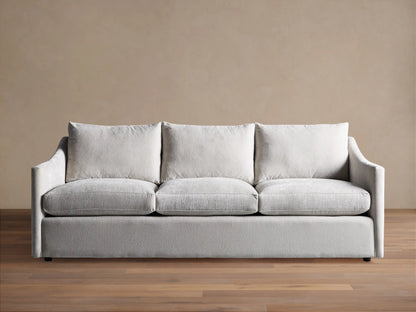 Light grey Branson Sofa with 3 seat & 3 back cushions, wide sloped arms, and a skirted base, shown front-on.