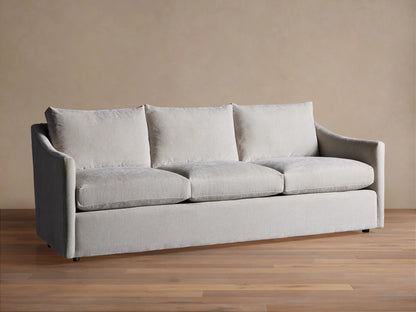 Light grey Branson Sofa with 3 seat & 3 back cushions, wide sloped arms, and a skirted base, shown front-on.