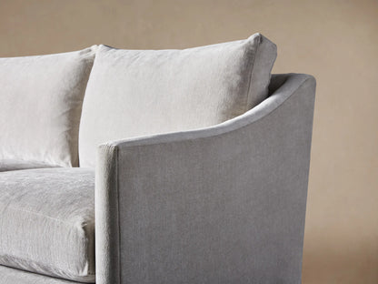 Branson Sofa, light gray fabric, 3-seater, with soft cushions, gently curved arms, and a skirted base, on a wood floor.