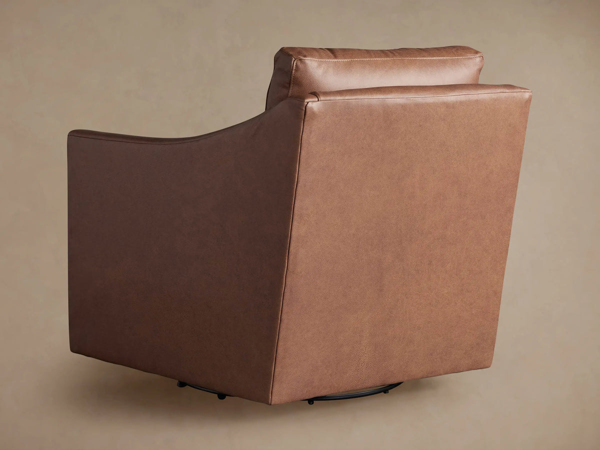 Close-up of Branson Leather Swivel Chair, textured brown leather armrest, seat, and back cushion with stitching details.