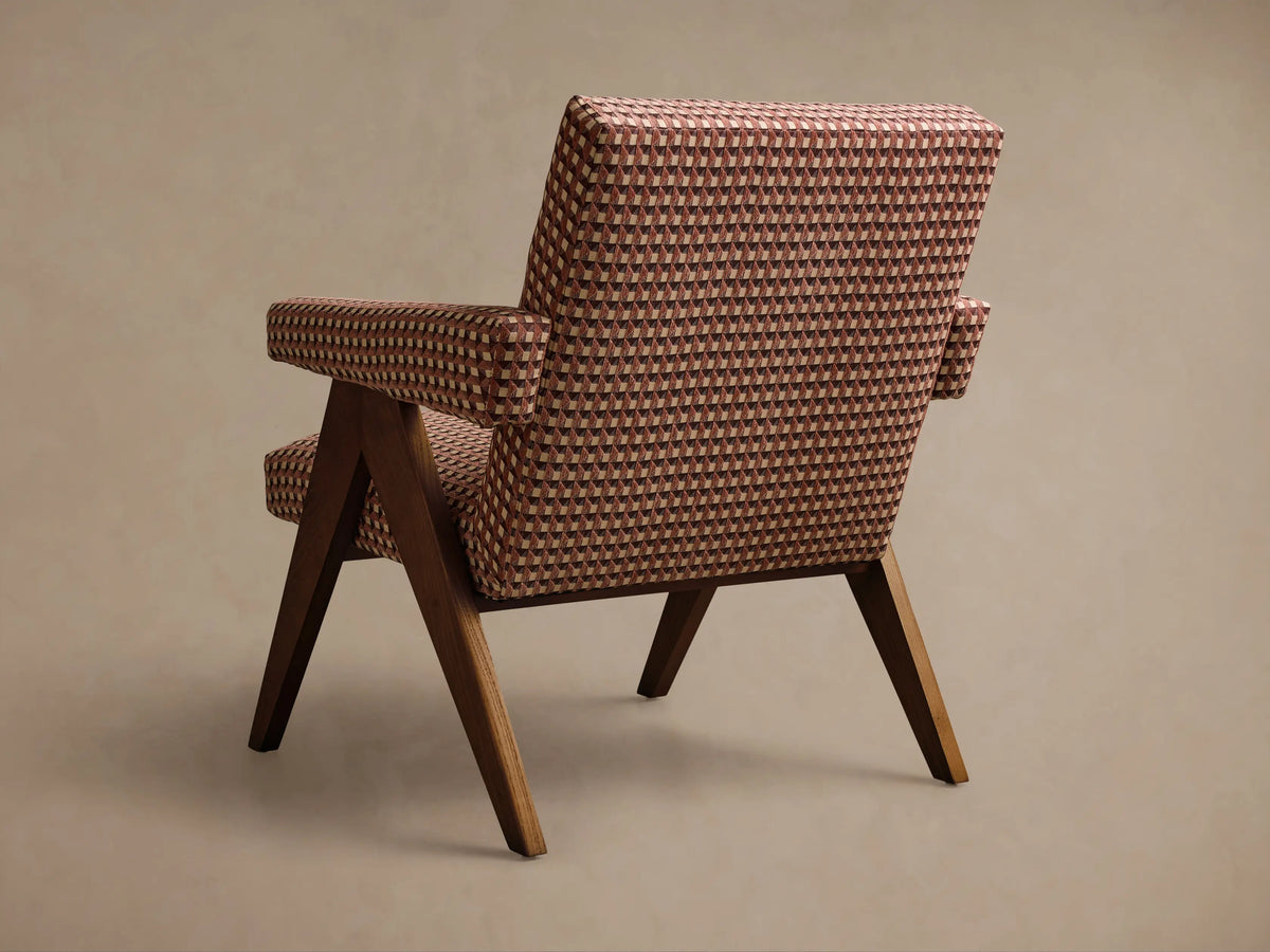 Angled view of Elias Chair with brown, cream, and reddish-brown geometric checkerboard upholstery and dark wooden frame.