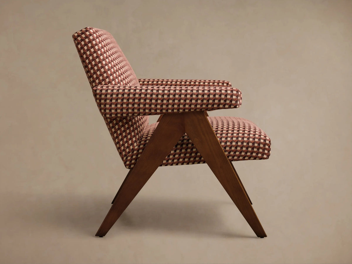Rear view of the Elias Chair, upholstered in a geometric pattern of brown, red, and beige, with visible dark wood legs.