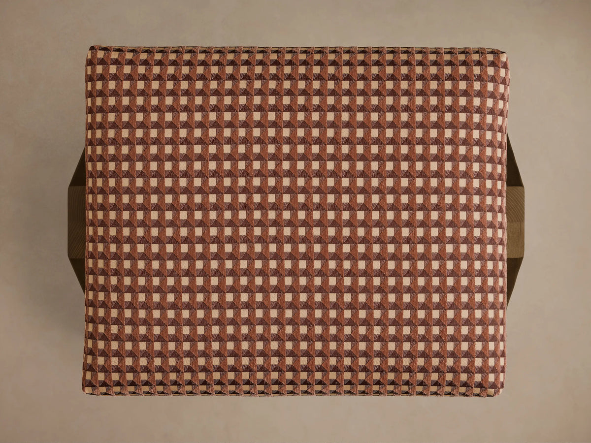 Overhead view of the Elias Ottoman, upholstered in a brown and beige isometric tile pattern of small squares.