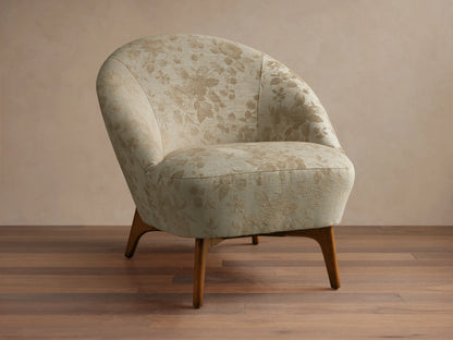 Front view of the beige floral Elodie Chair with a rounded back and tapered wooden legs.