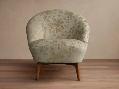 Front view of the light beige Elodie Chair, armless with a rounded back, subtle fabric pattern, and dark wood legs.