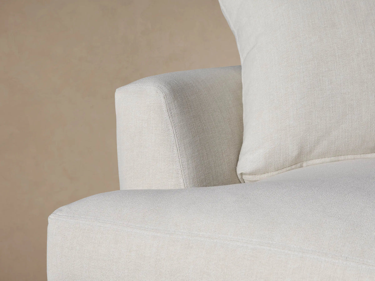 Light beige Emory Chair, a plush, oversized armchair with a deep seat and two soft cushions, on a wood floor.