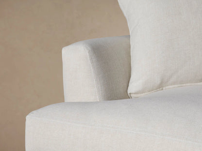 Light beige Emory Chair, a plush, oversized armchair with a deep seat and two soft cushions, on a wood floor.