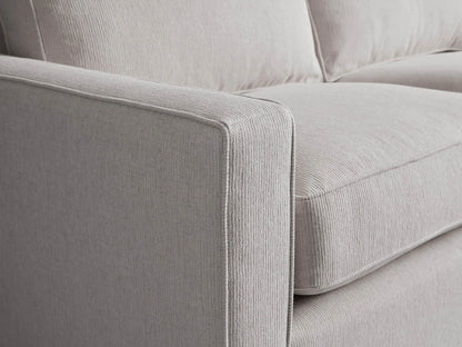 Filmore Air Sleeper Sofa, light gray heathered fabric, two seat/back cushions, square arms, on wood floor against a neutral wall.