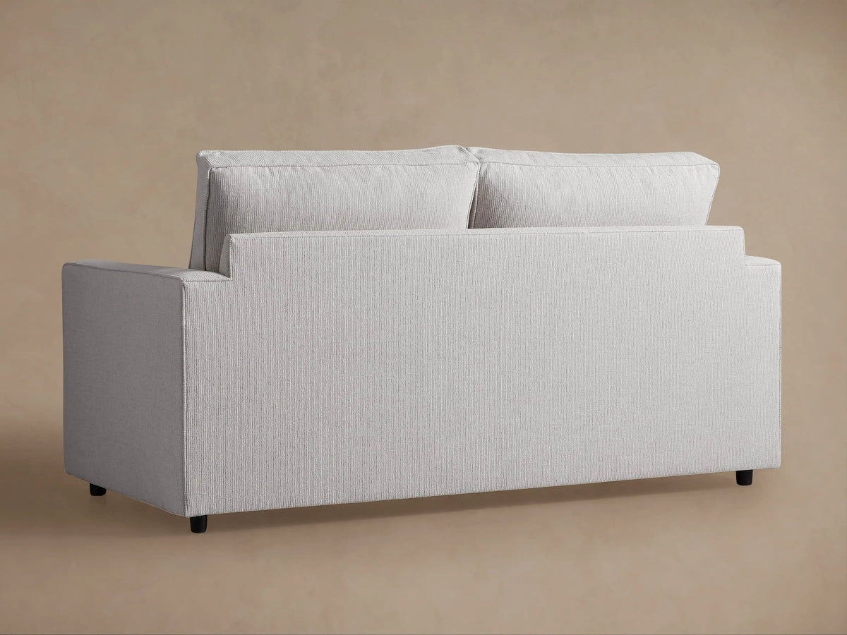 Close-up of the Filmore Air Sleeper Sofa, showing the light grey, subtly ribbed fabric on the arm and cushions.