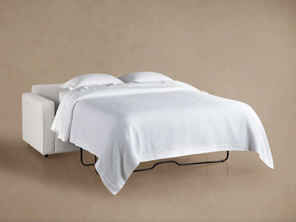 Filmore Air Sleeper Sofa, light grey textured fabric, viewed from back-left. Two plush back cushions visible, modern boxy design.