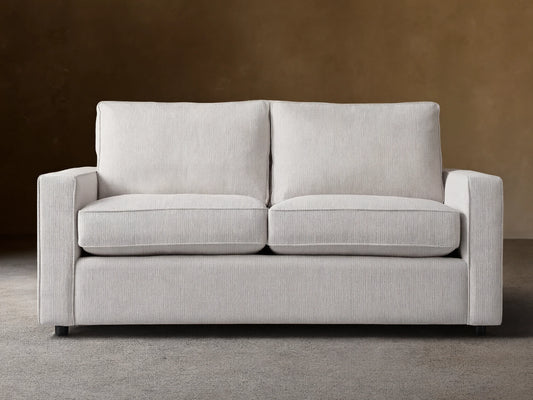 Filmore Air Sleeper Sofa: light gray two-seat sofa with square arms, textured fabric, on a wood floor.