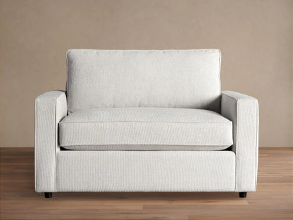 Filmore Twin Air Sleeper Chair, light gray textured fabric, front view, on wood floor against brown wall.