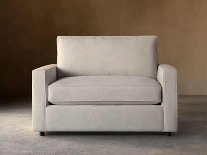 Filmore Twin Air Sleeper Chair, light gray textured fabric, front view, on wood floor against brown wall.