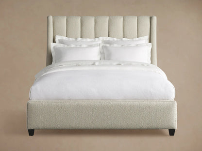 Hayworth Bed: Light beige textured upholstery, channel-tufted headboard, white bedding, dark feet, on wood floor.