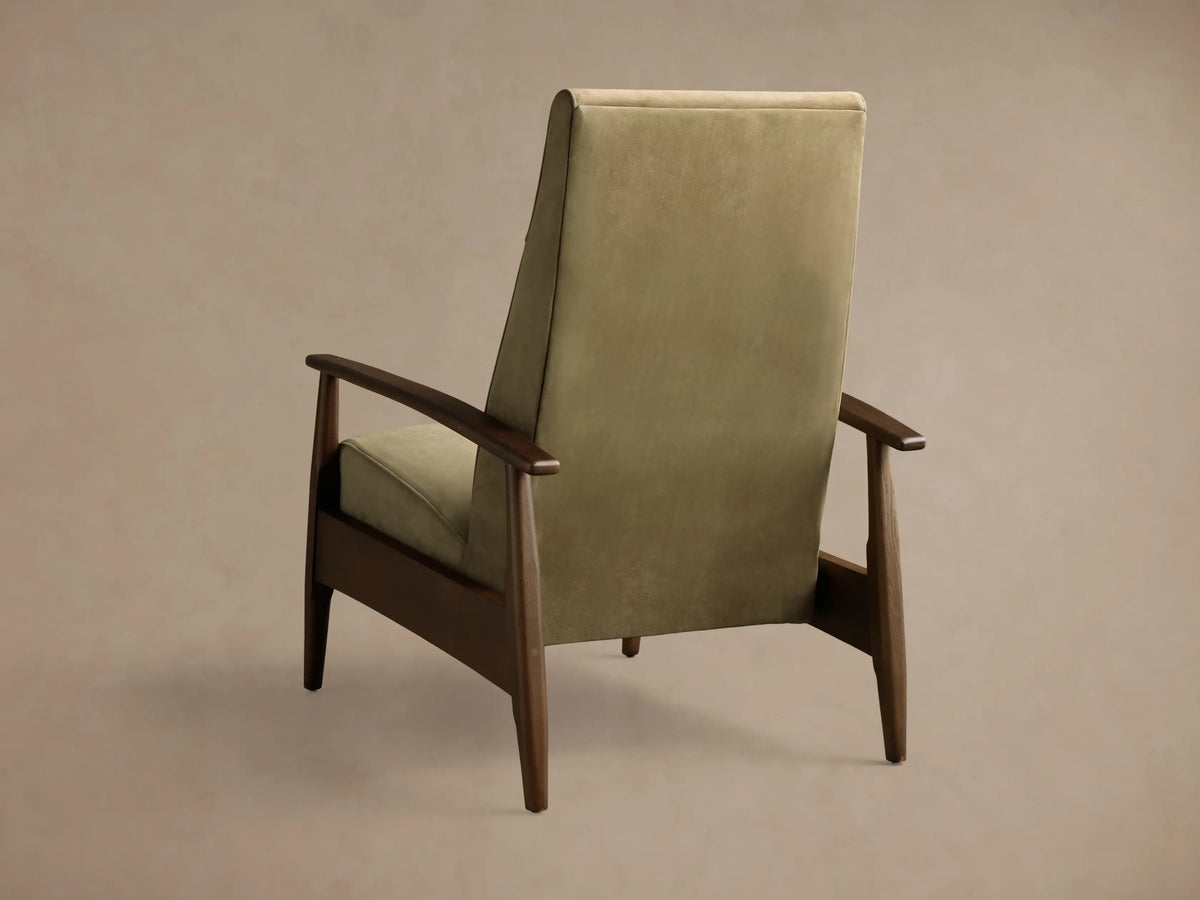 Rear 3/4 view of a high-back armchair with light olive green upholstery and dark brown wooden frame.