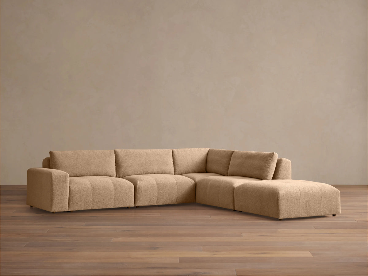 Blue and beige floral Keegan Five-Piece Sectional in an L-shape, with throw pillows, in a sunlit living room scene.