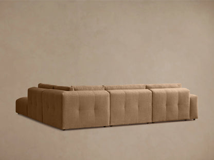 Tan Keegan Five-Piece Sectional with plush, textured fabric. Features tufted cushions and a low backrest in a cozy setting.