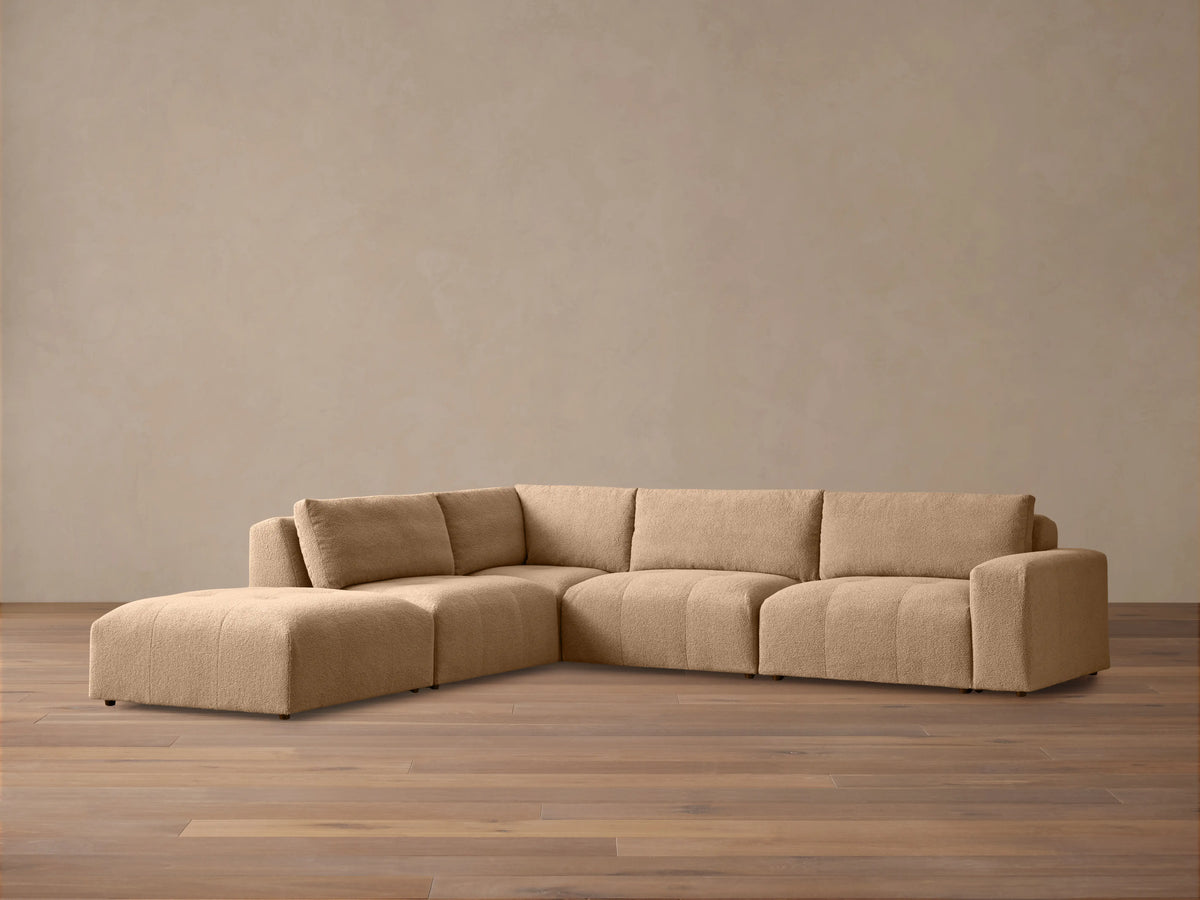 Keegan Five-Piece Sectional in blue and cream botanical print fabric, with accent pillows, in a sunlit living room setting.