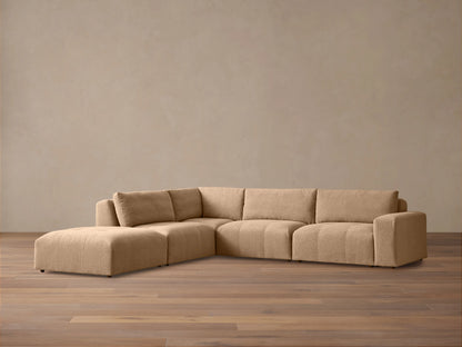 Keegan Five-Piece Sectional in blue and cream botanical print fabric, with accent pillows, in a sunlit living room setting.