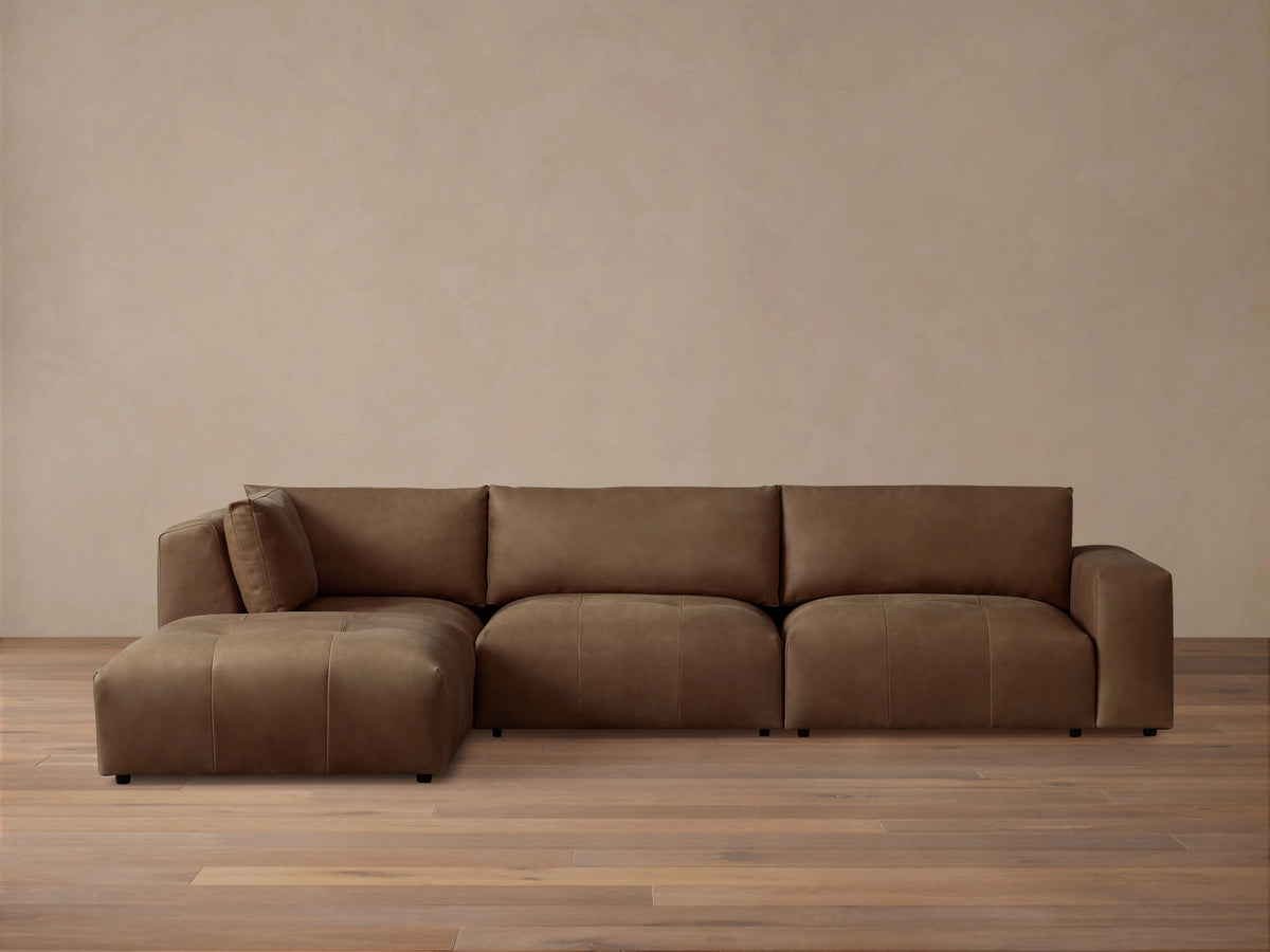 Keegan Leather Four-Piece Sectional in rich brown leather, features a left-facing chaise, three cushioned seats, and wide armrests on a wooden floor.