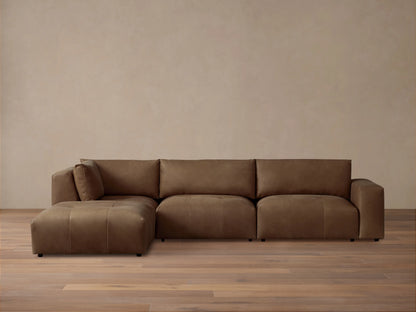 Keegan Leather Four-Piece Sectional in rich brown leather, features a left-facing chaise, three cushioned seats, and wide armrests on a wooden floor.